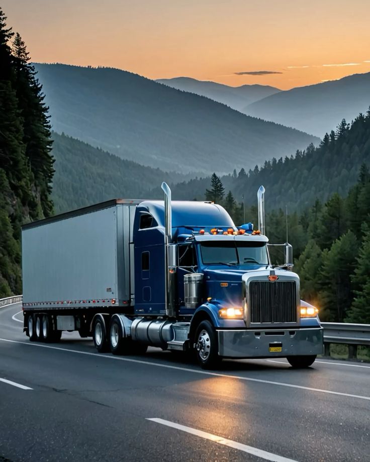 Blue semi truck with dry van at sunset in the mountains