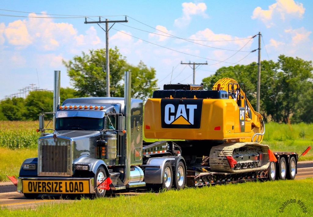 Excavator transport with oversize load banner